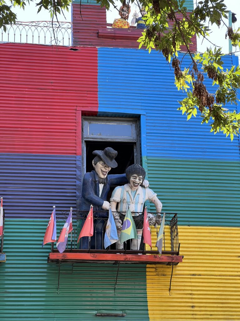 Colorful wall. Balcony with statues.